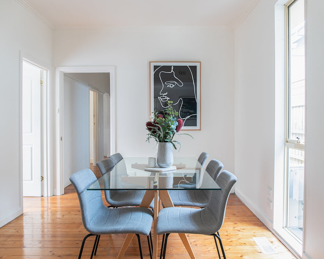 a dining room table with a vase of flowers on top of it