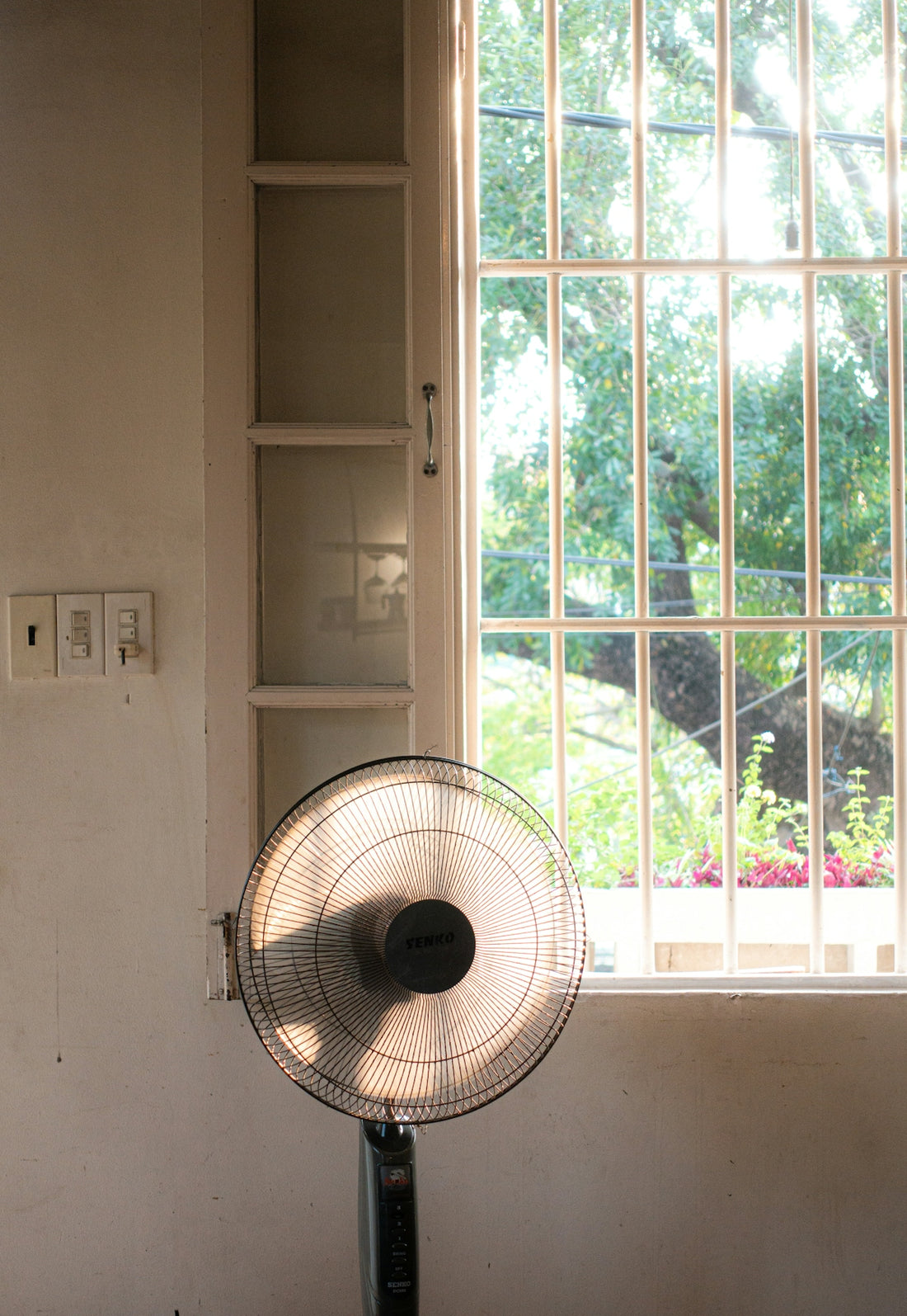 a fan sitting in front of a window in a room