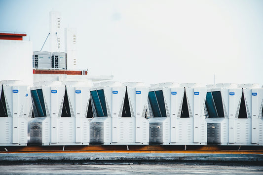 a row of portable air conditioners sitting on top of a roof