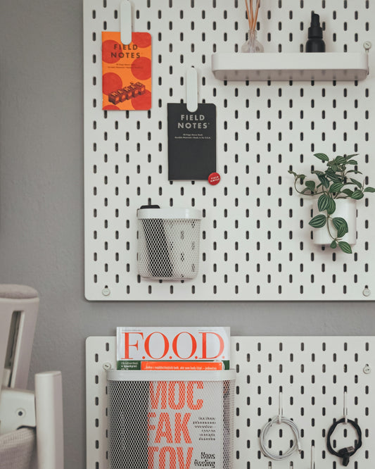 A couple of white pegboards mounted to the side of a wall