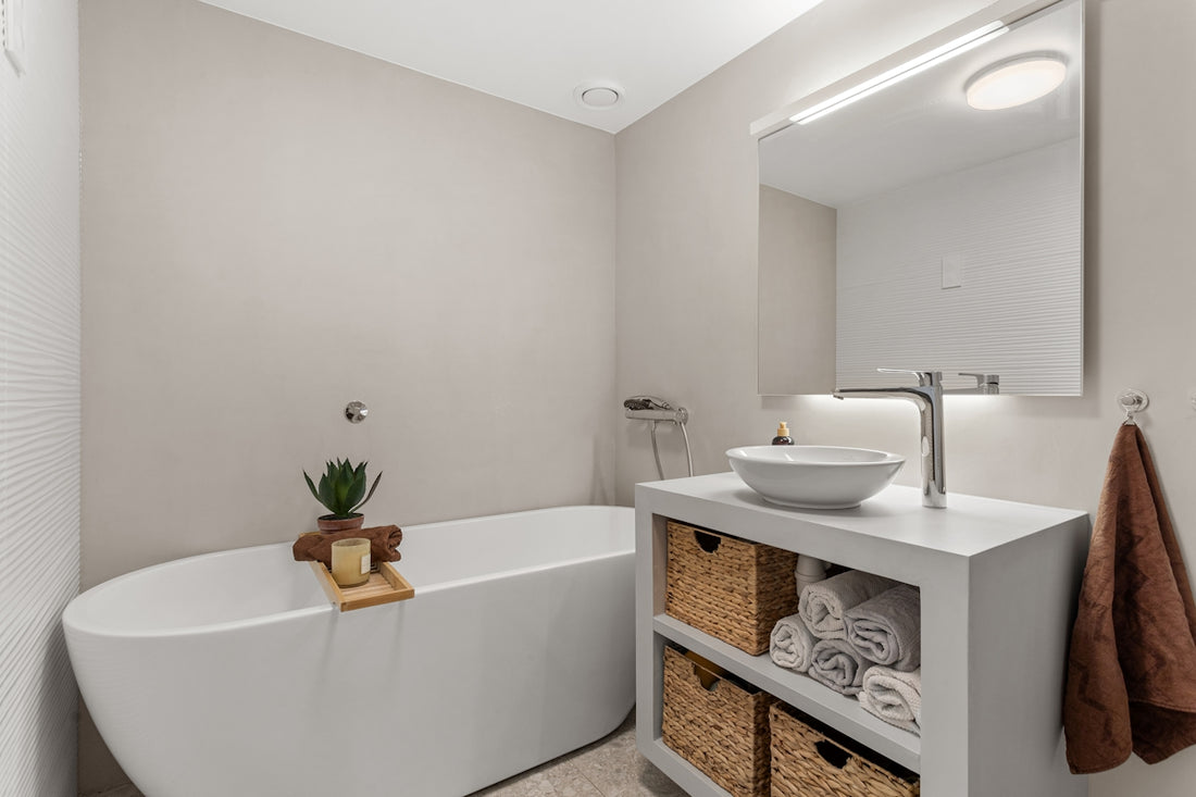 A bathroom with a tub, sink and mirror