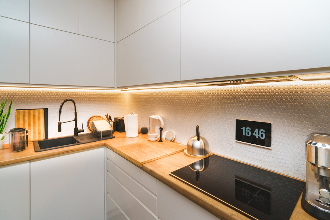 A kitchen with white cabinets and a black stove top