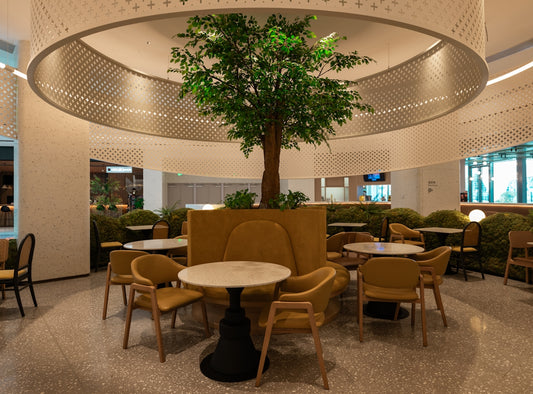 A large room with tables and chairs and a tree