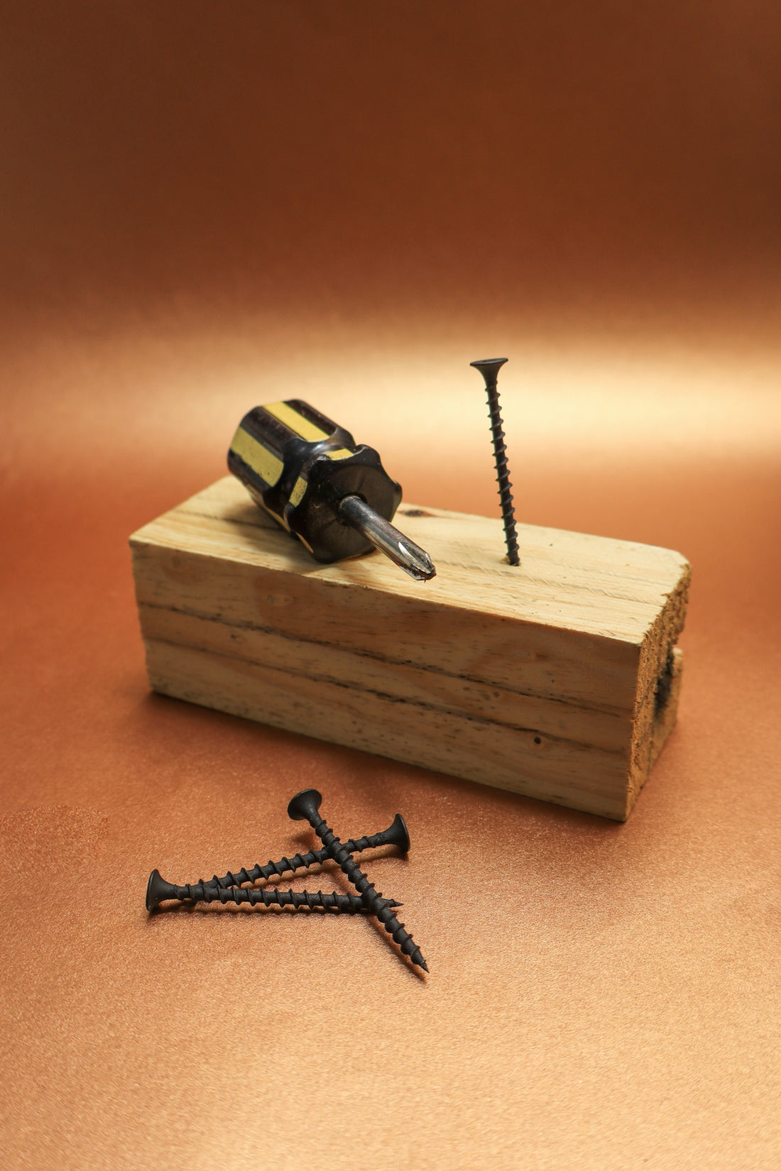 Screws, screwdriver, and wood block