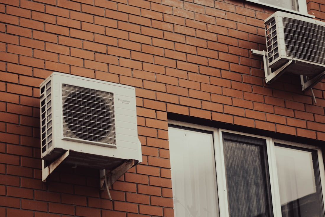 Air conditioners are attached to a brick building