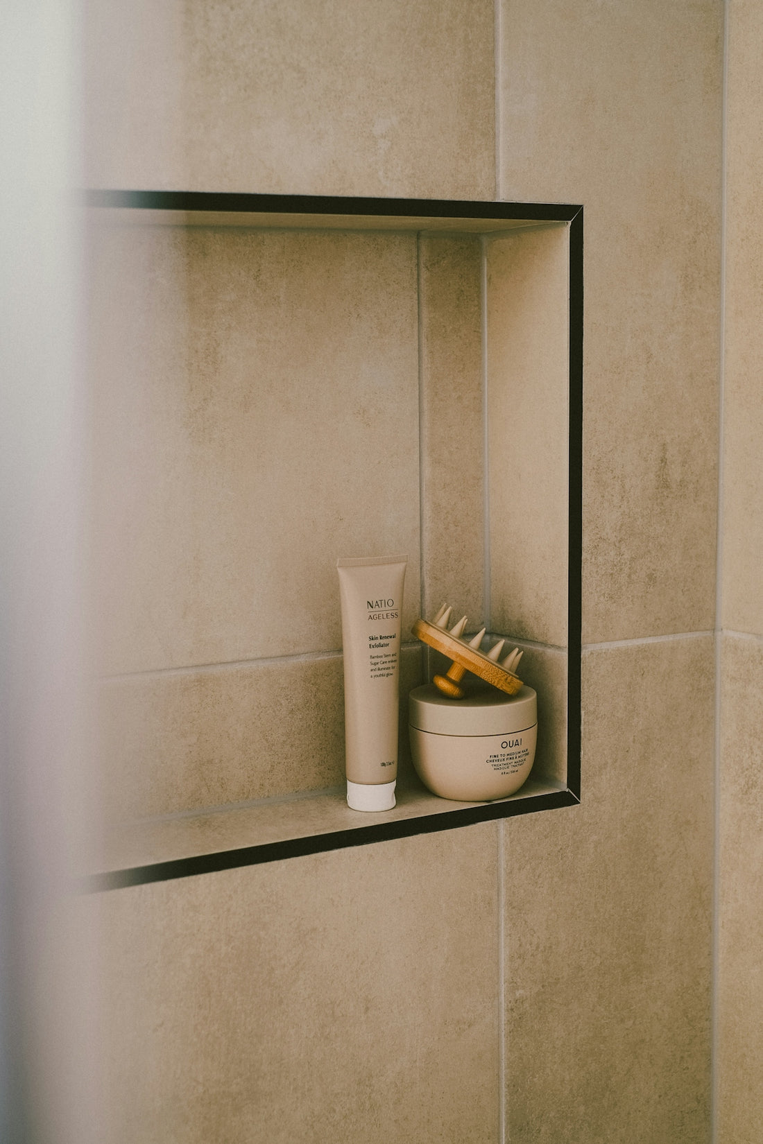 Bathroom products sit inside a tiled niche.