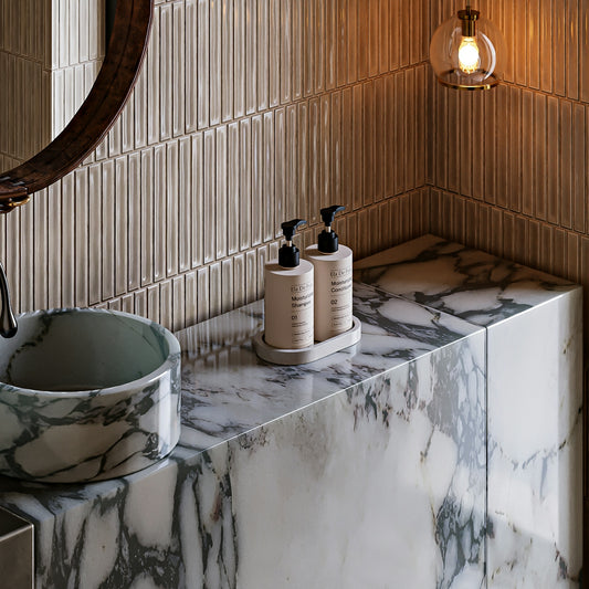 Modern bathroom vanity with marble countertop and sink.