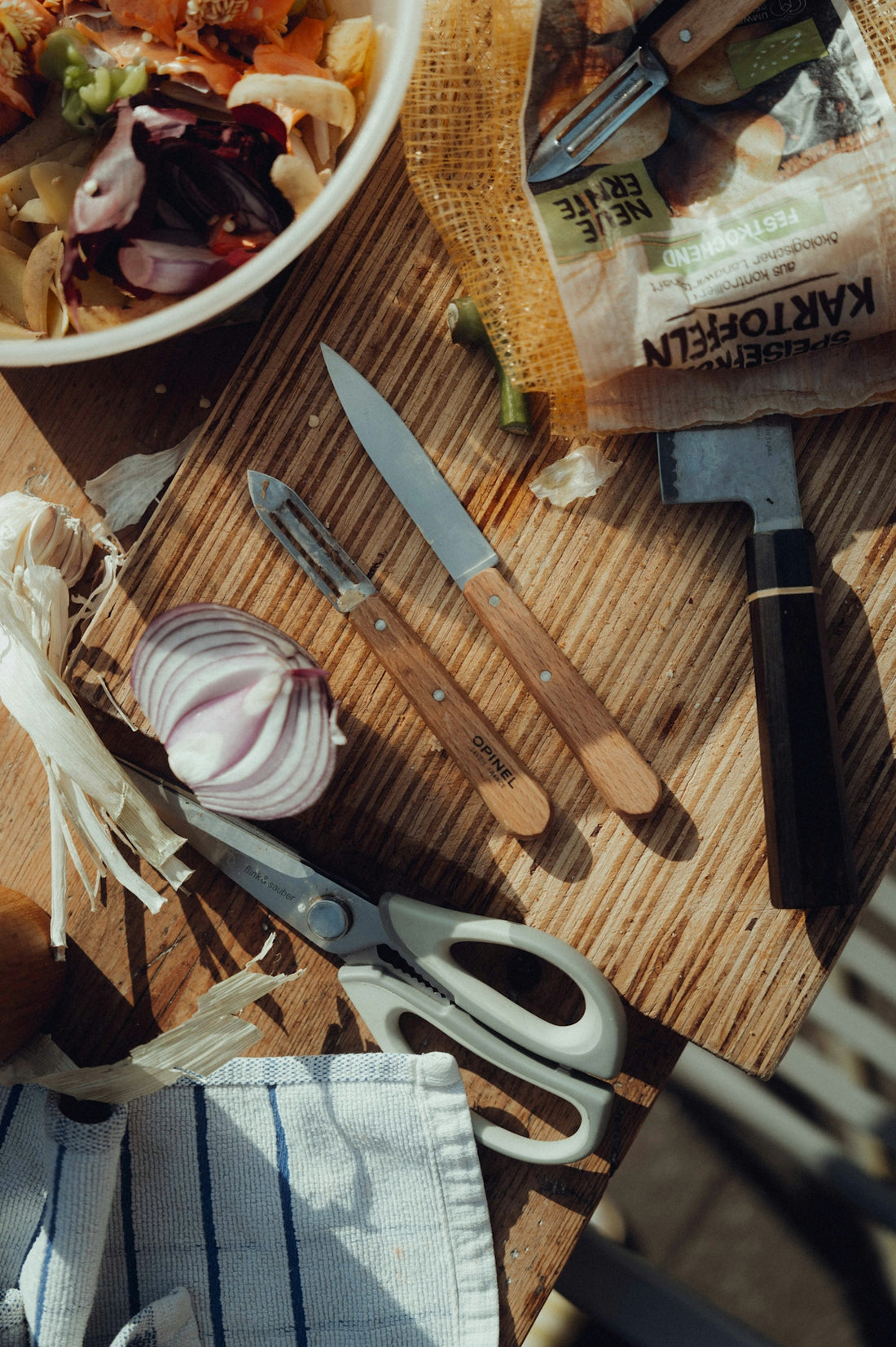 Onion, garlic, and potatoes with kitchen tools