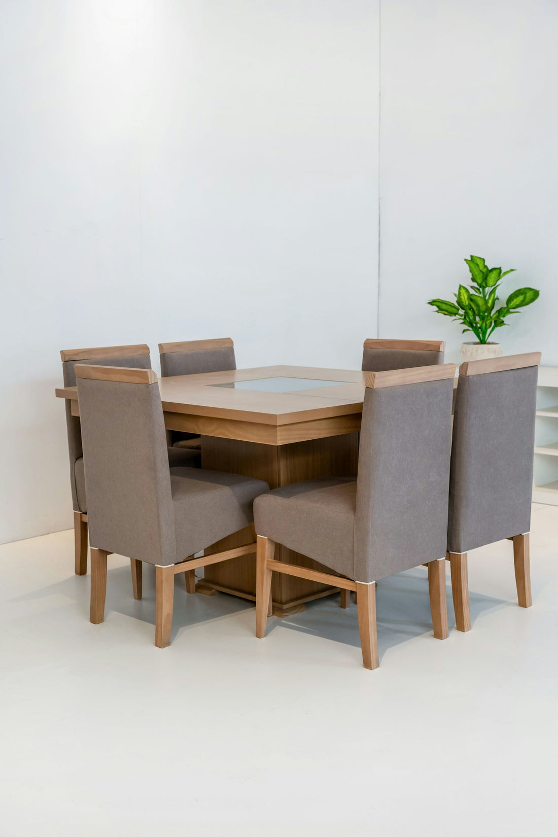 Dining table with six upholstered chairs in a bright room.