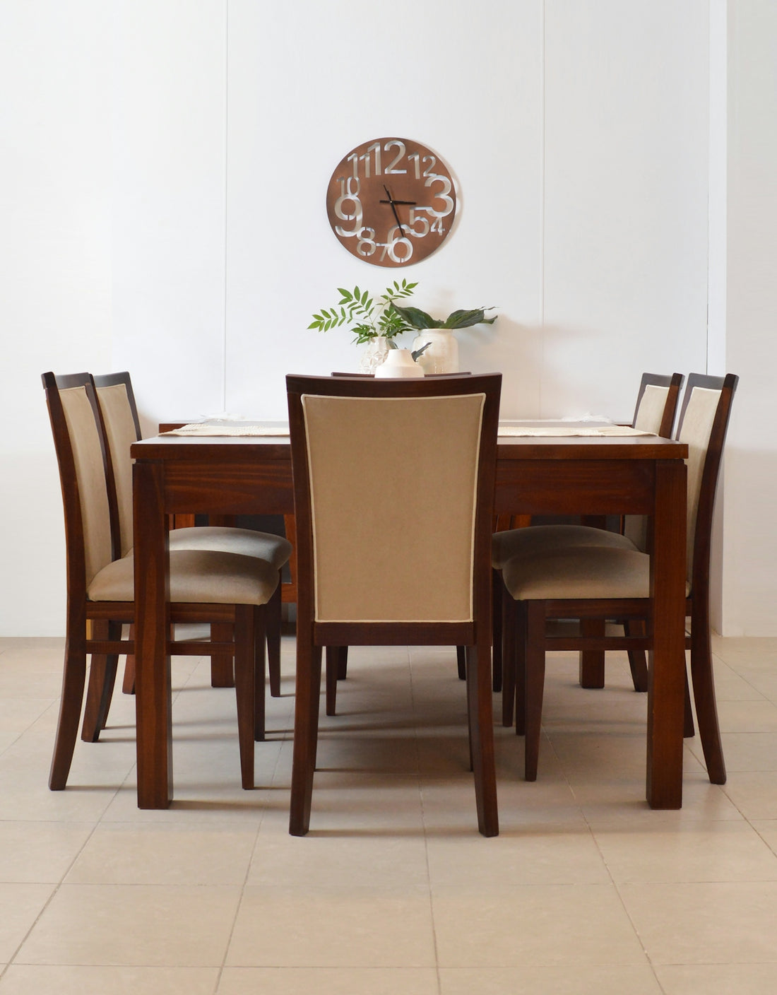 Wooden dining table with upholstered chairs and clock