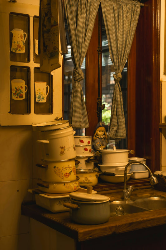 Stack of vintage pots and pans by a kitchen sink