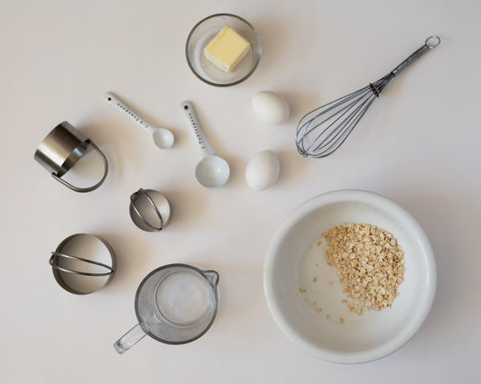 Baking ingredients and tools arranged on a white surface.