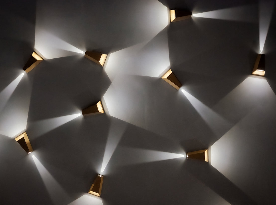 Modern wall sconces casting light patterns on wall