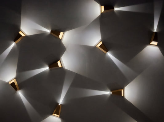 Modern wall sconces casting light patterns on wall
