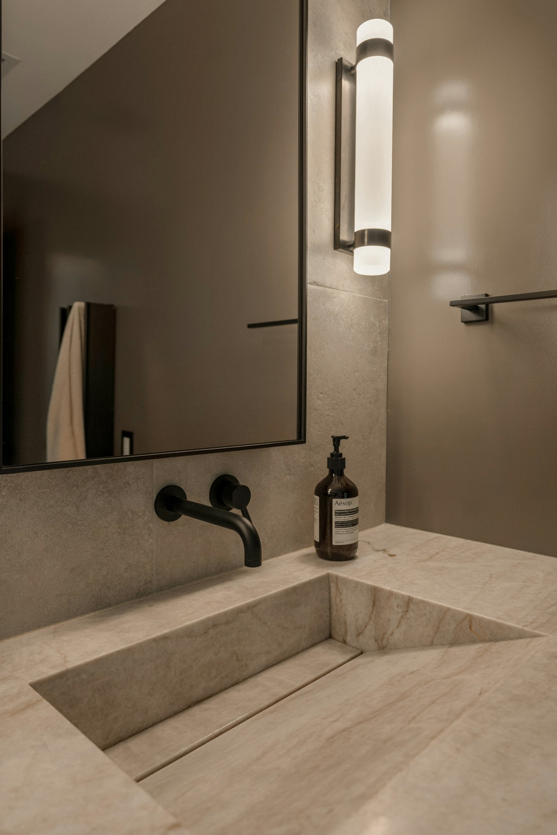 Modern bathroom with stone sink and black faucet