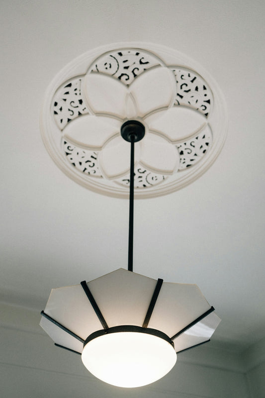 A decorative ceiling medallion with a modern pendant light.