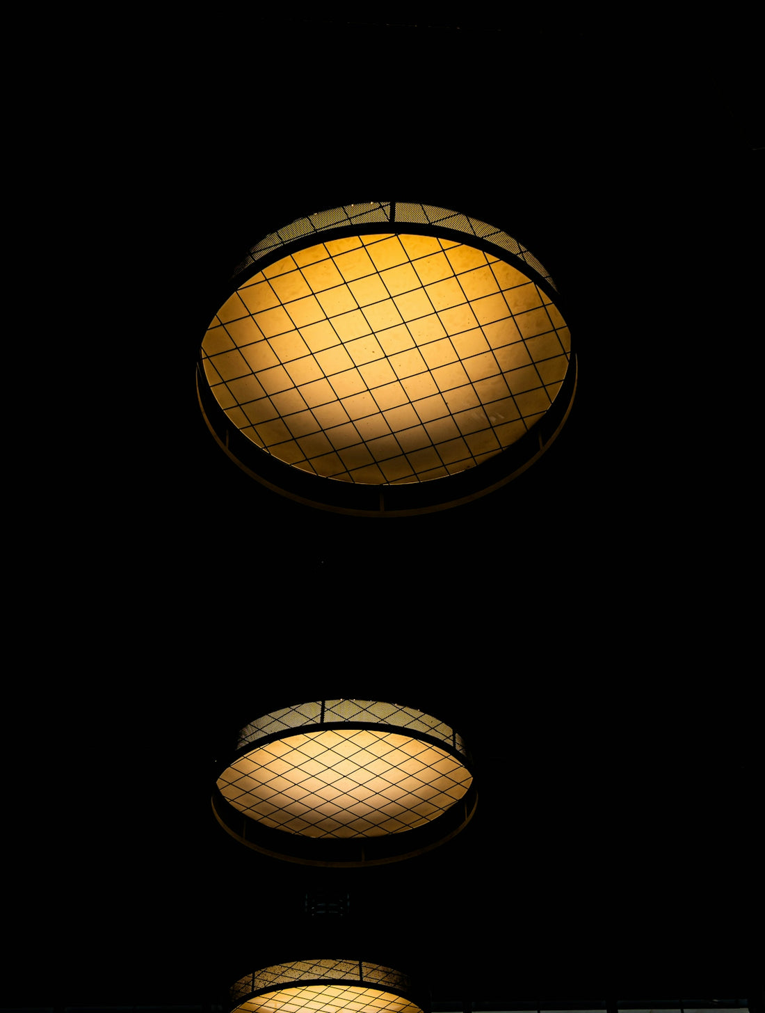 Two illuminated ceiling lights against a dark background