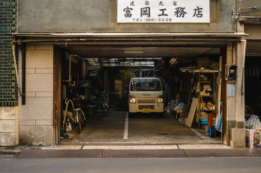 Small white van parked inside a garage workshop entrance