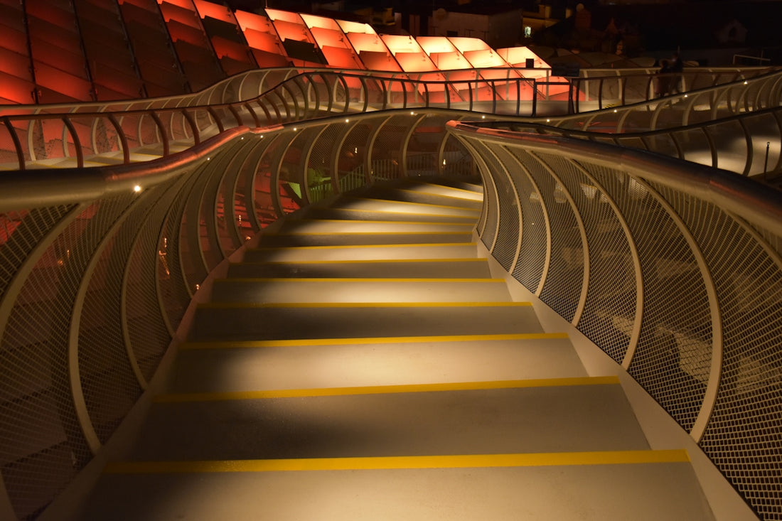 Modern illuminated walkway with curved metal railings