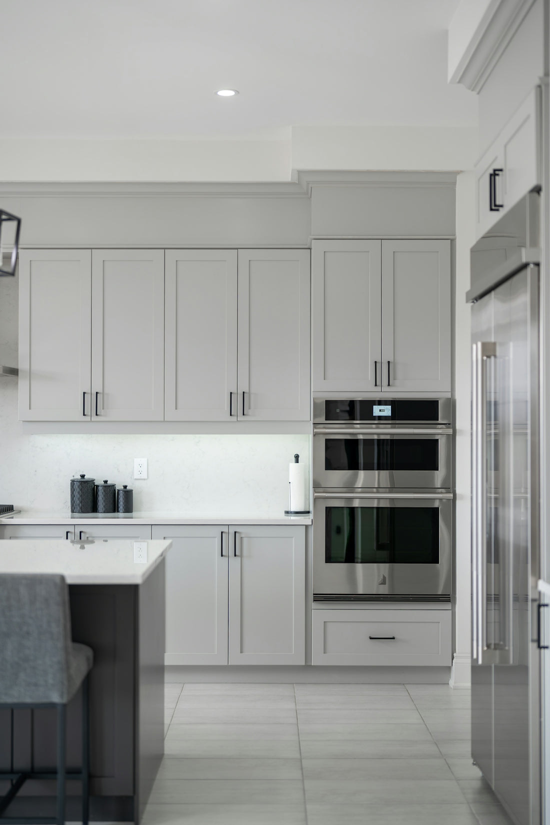 Modern kitchen with light gray cabinets and stainless steel appliances