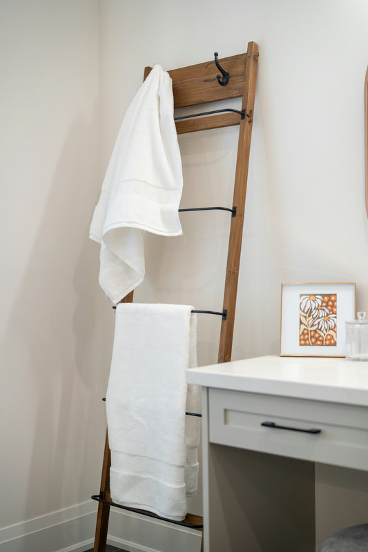 Wooden ladder rack with white towels in a bathroom