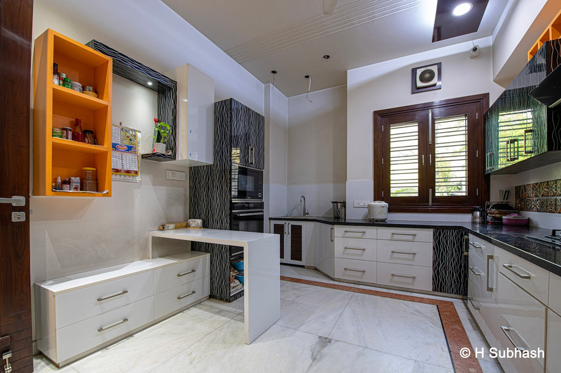Modern kitchen with white cabinets and orange shelves.