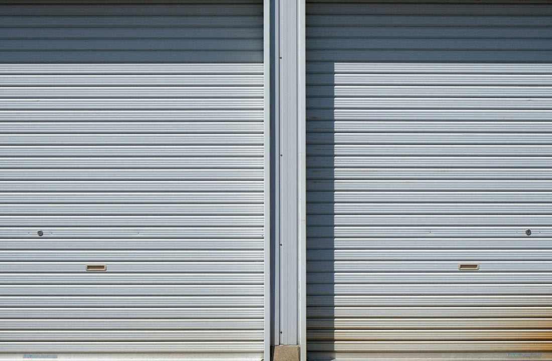 Two closed metal roll-up garage doors side by side