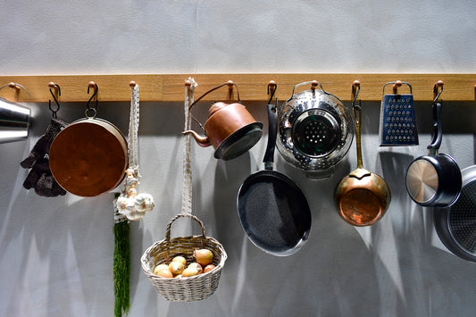 Various kitchen utensils hanging on a wooden rack.