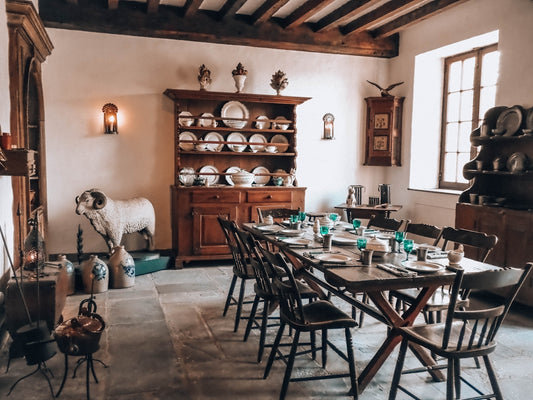 Old-fashioned dining room with set table and wooden furniture.