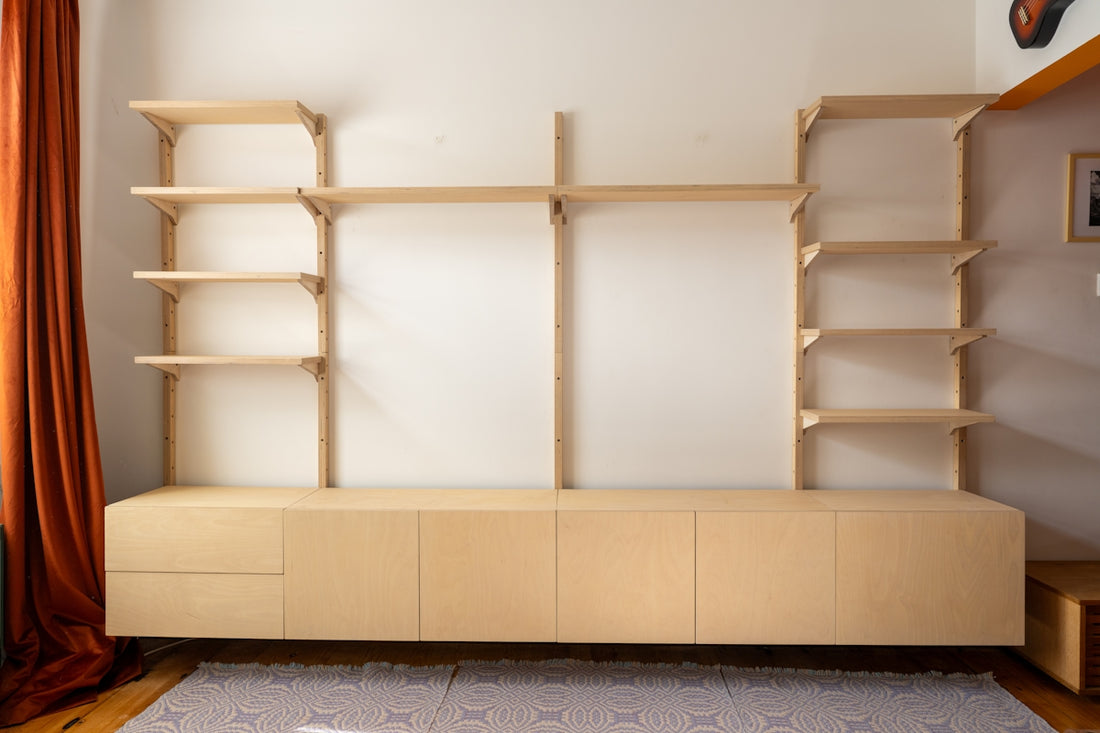 A modern light wood wall unit with shelves and cabinets.