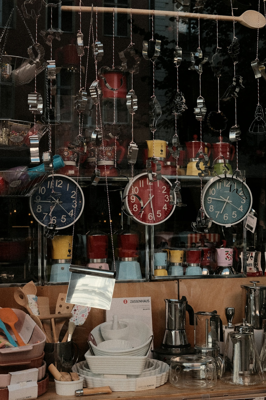 Shop display with colorful clocks, coffee makers, and kitchen utensils.