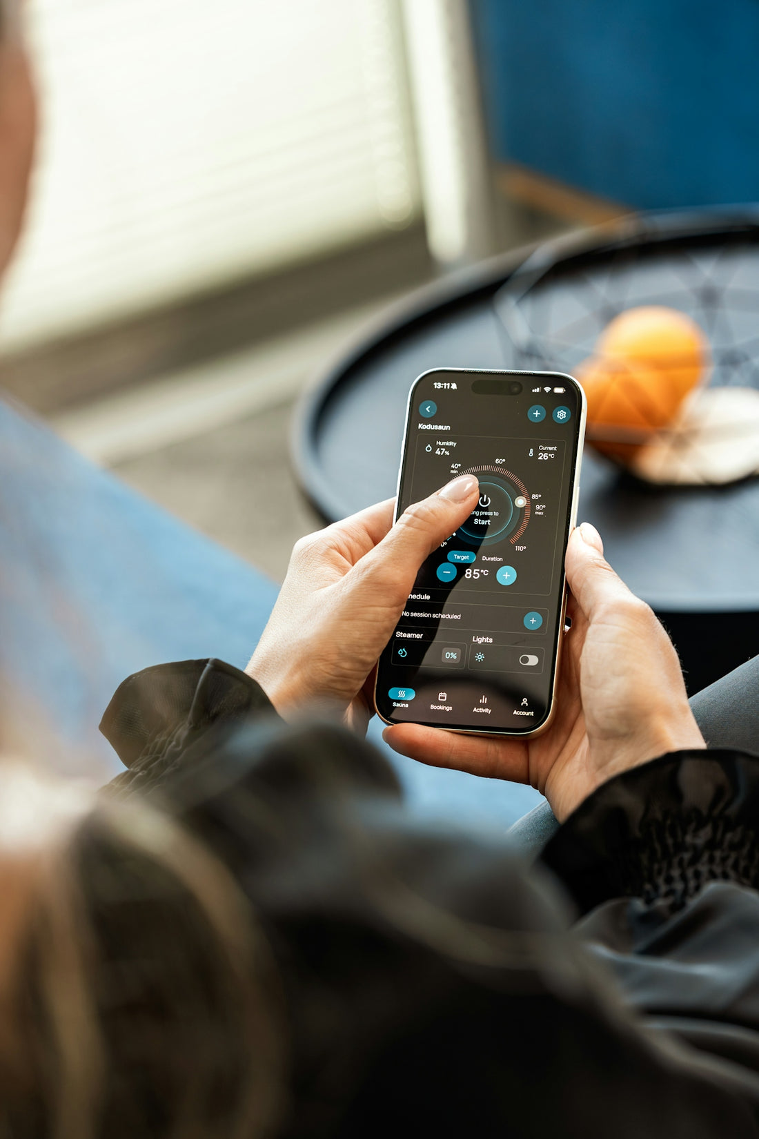 Hands holding a smartphone displaying a smart control application.