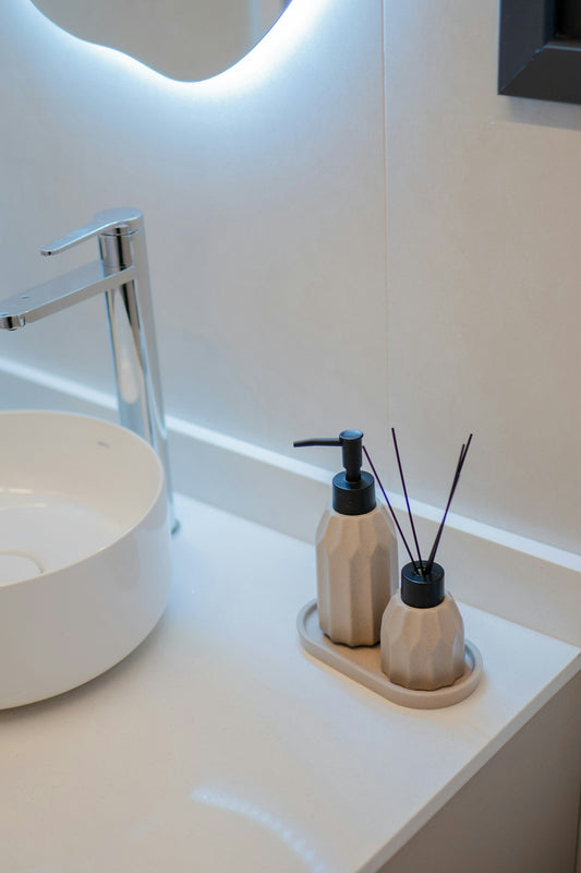 A modern bathroom sink with a faucet and decorative bottles.
