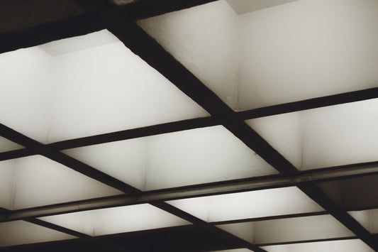 Illuminated square ceiling panels creating a geometric grid pattern.