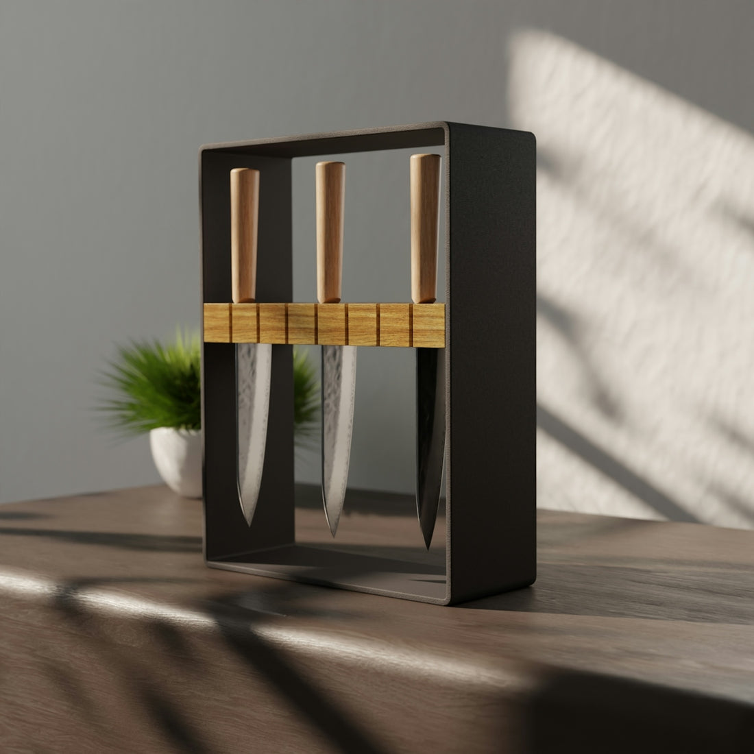 Three kitchen knives with wooden handles in a dark metal stand on a table