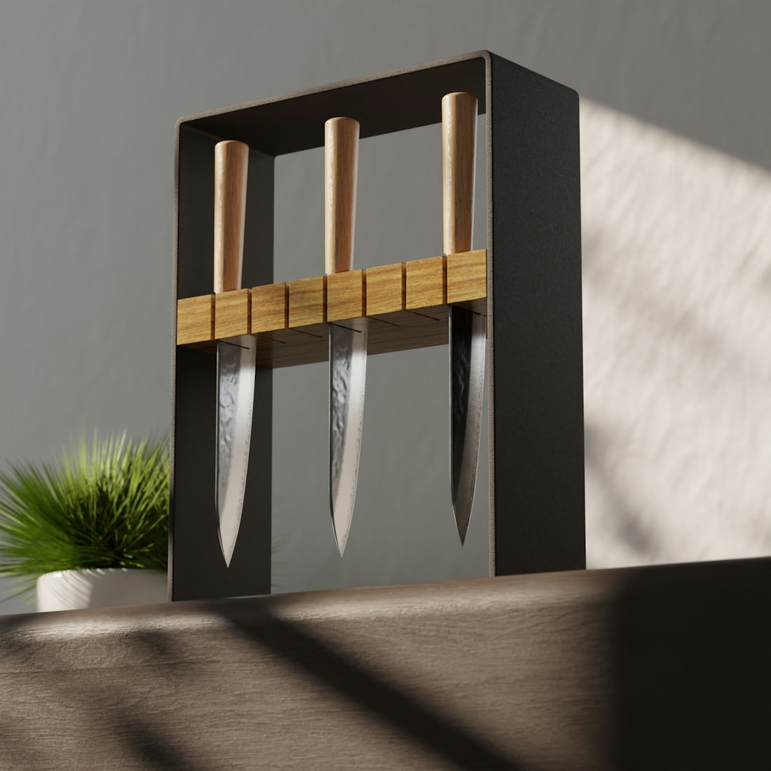 Three kitchen knives with wooden handles in a black metal stand on a table